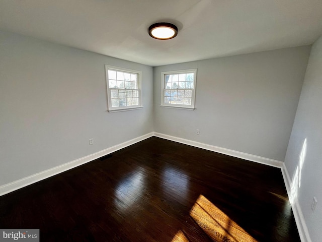 spare room with dark wood-type flooring