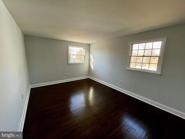 empty room with dark hardwood / wood-style floors