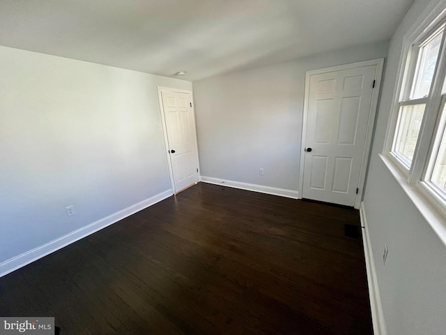 empty room with dark wood-type flooring