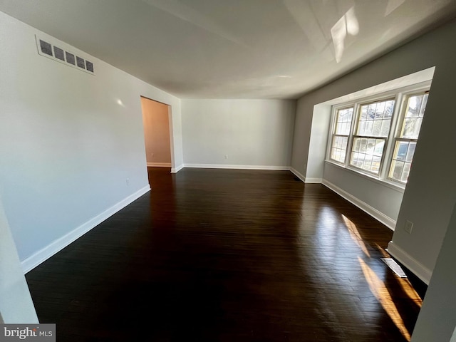 spare room featuring dark wood-type flooring