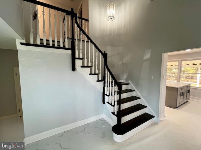 staircase featuring a chandelier