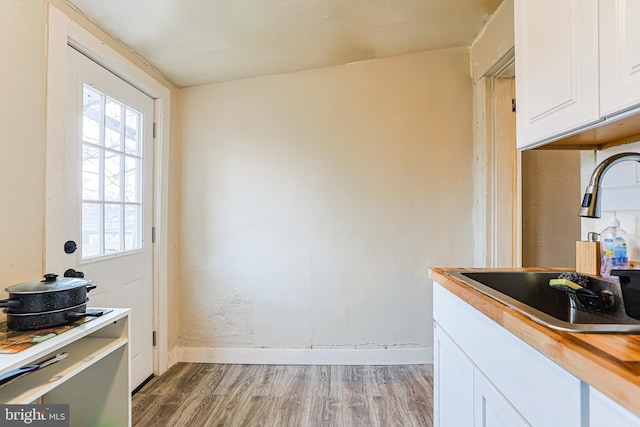 813 Greenhill Rd, Sharon Hill, PA 19079 - kitchen featuring butcher block counters, sink, white cabinets, and light hardwood / wood-style floors