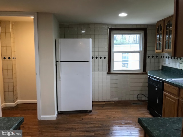 kitchen with tile walls, dark hardwood / wood-style floors, dishwasher, and white refrigerator