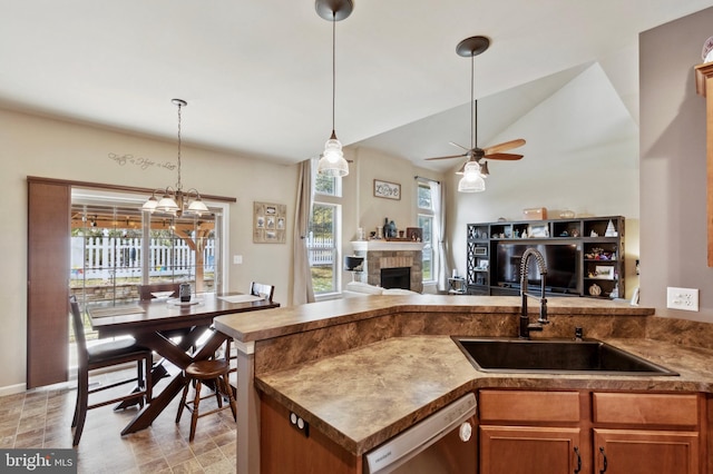 kitchen with a fireplace, sink, hanging light fixtures, stainless steel dishwasher, and ceiling fan