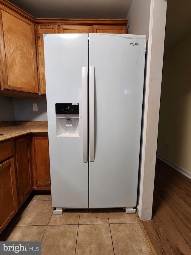 kitchen featuring light tile patterned floors and white fridge with ice dispenser