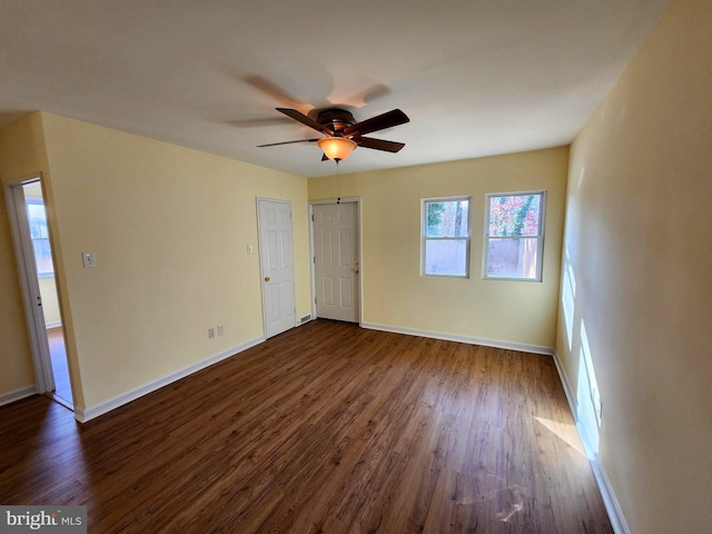 empty room with ceiling fan and dark hardwood / wood-style flooring