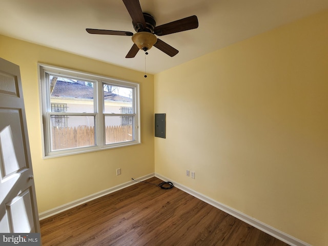 unfurnished room featuring ceiling fan, dark hardwood / wood-style floors, and electric panel