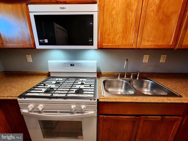 kitchen featuring white gas range and sink