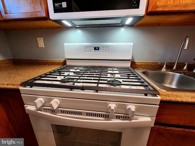 kitchen featuring sink and white gas range oven