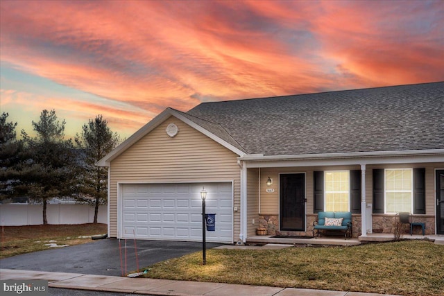 view of front of property featuring a garage and a lawn