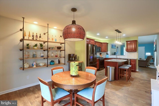 dining space featuring sink and hardwood / wood-style flooring