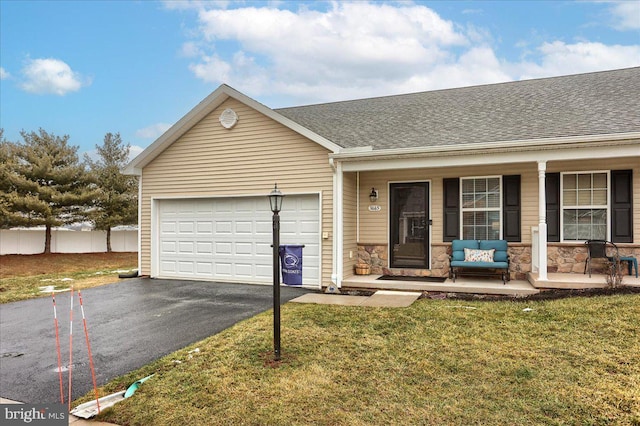 ranch-style home with a garage, a front yard, and covered porch