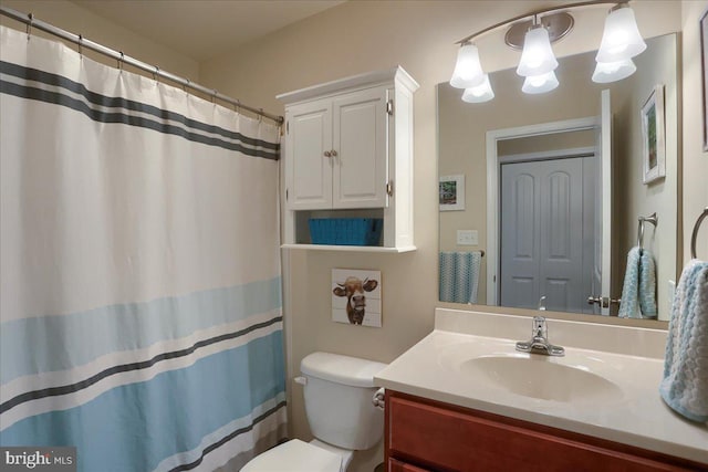 bathroom featuring vanity, toilet, and a chandelier