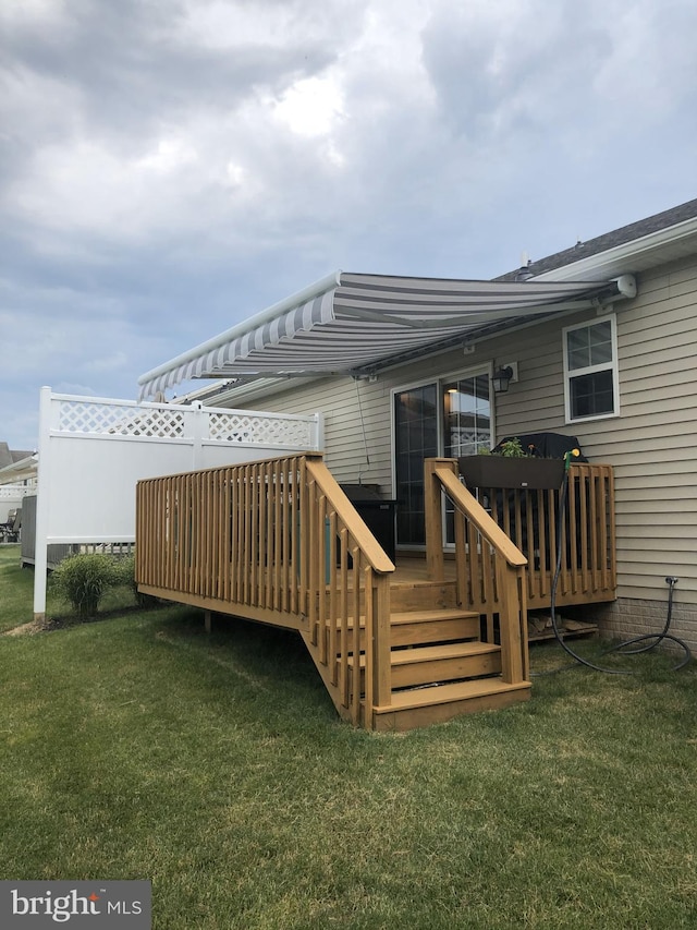 wooden deck featuring a lawn