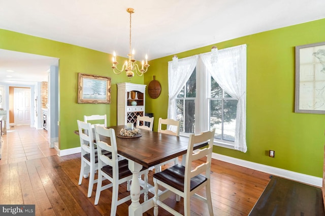 dining room with a notable chandelier and dark wood-type flooring