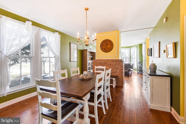 dining space with dark hardwood / wood-style floors and an inviting chandelier