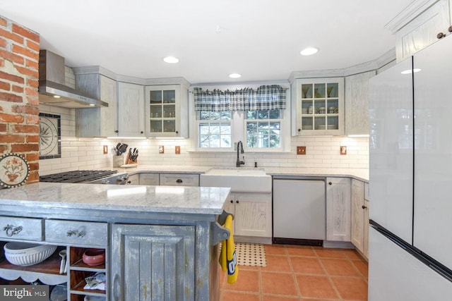 kitchen with white cabinetry, sink, wall chimney range hood, and white refrigerator