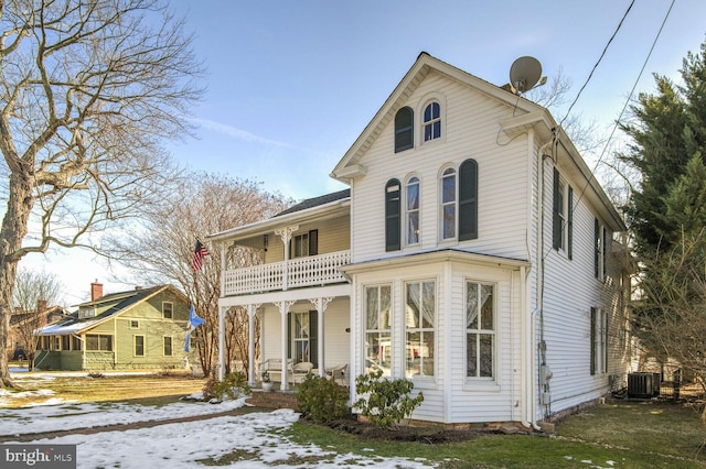 view of front of property featuring a porch, a balcony, and central AC unit