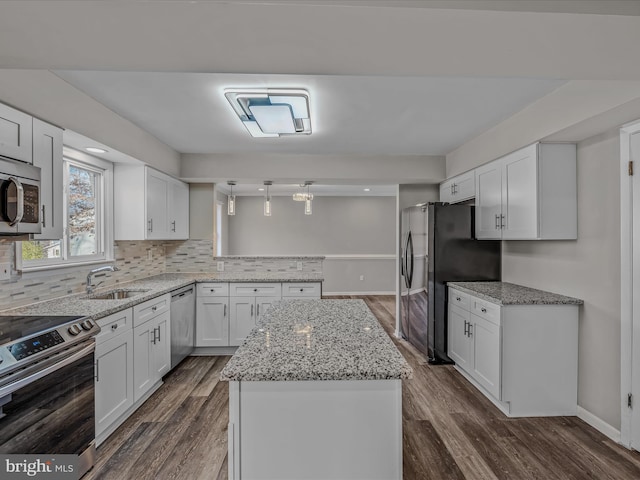 kitchen with dark wood-type flooring, sink, appliances with stainless steel finishes, white cabinets, and backsplash