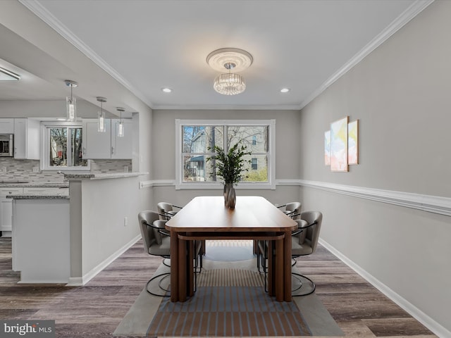 dining space with dark hardwood / wood-style flooring, a notable chandelier, plenty of natural light, and ornamental molding