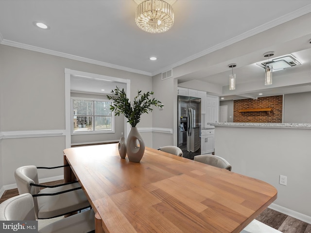 dining room featuring ornamental molding, a chandelier, and hardwood / wood-style floors