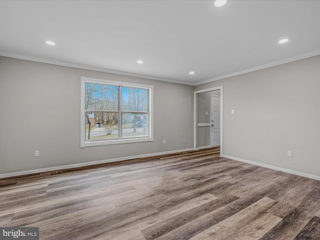 spare room with hardwood / wood-style floors and crown molding