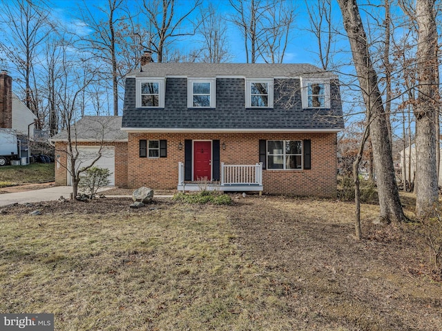 view of front of house featuring a garage, covered porch, and a front lawn