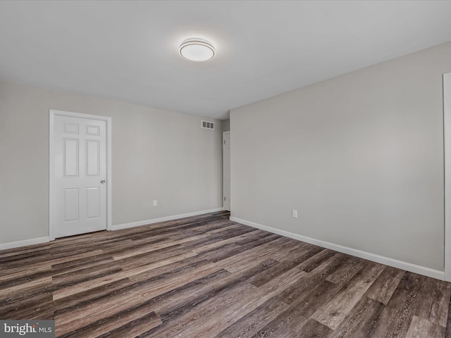 unfurnished room with dark hardwood / wood-style flooring