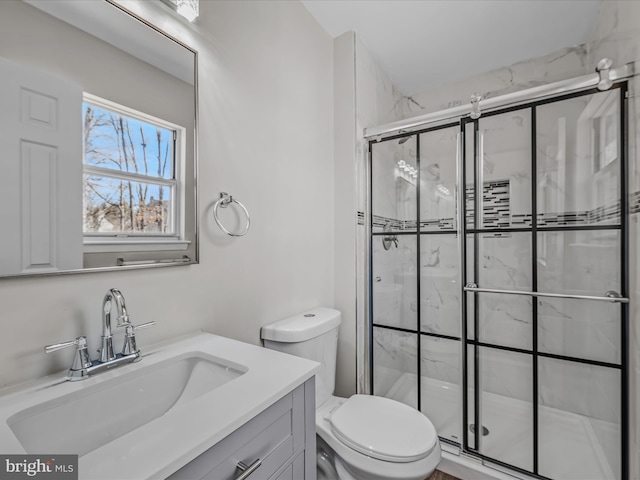 bathroom with an enclosed shower, vanity, and toilet