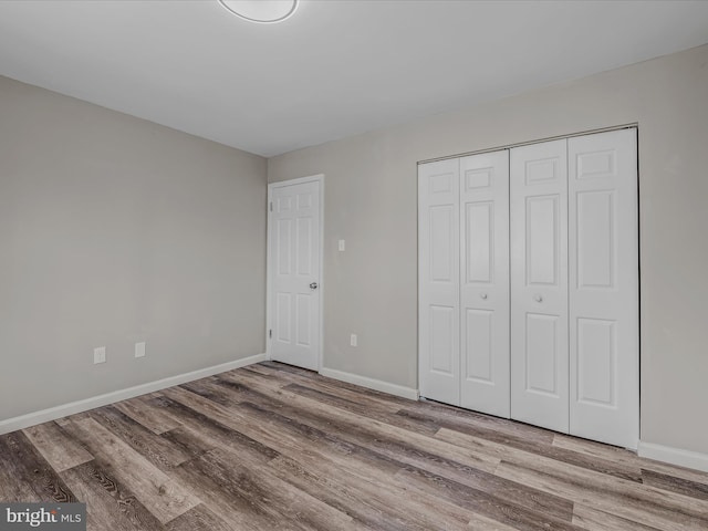 unfurnished bedroom featuring hardwood / wood-style floors and a closet