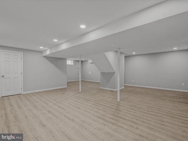 basement with light hardwood / wood-style flooring