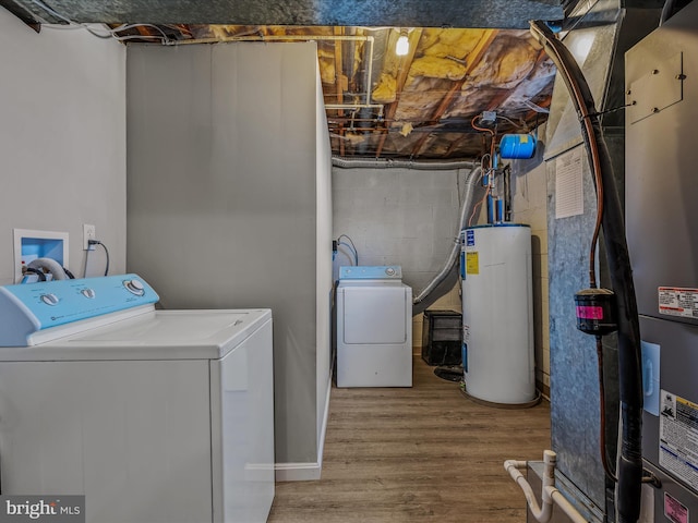 laundry room featuring water heater, separate washer and dryer, and hardwood / wood-style floors