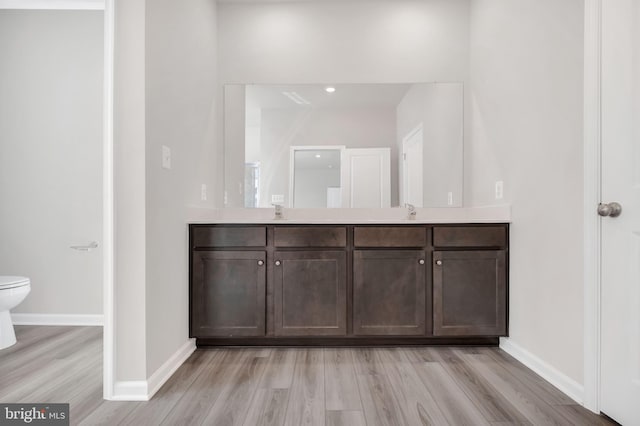 bathroom featuring hardwood / wood-style flooring, vanity, and toilet