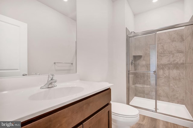 bathroom featuring vanity, toilet, and an enclosed shower