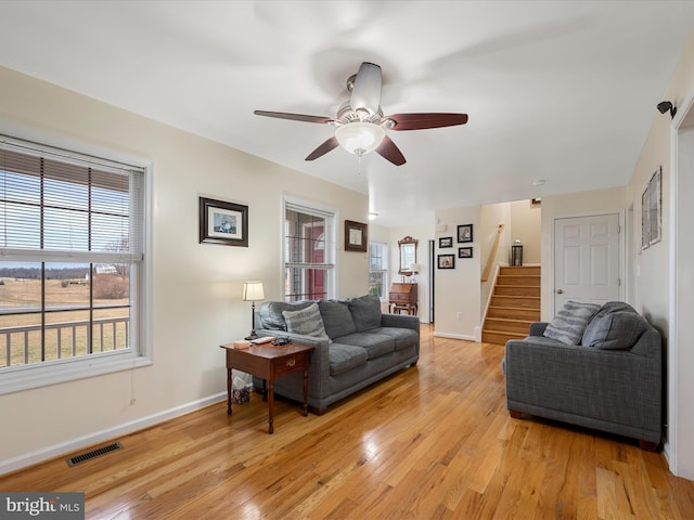 living room featuring light hardwood / wood-style floors and ceiling fan