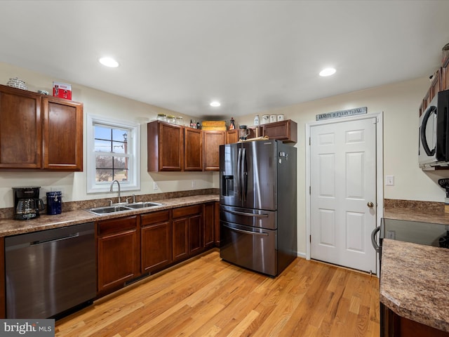 kitchen with dishwashing machine, sink, fridge with ice dispenser, and light hardwood / wood-style floors