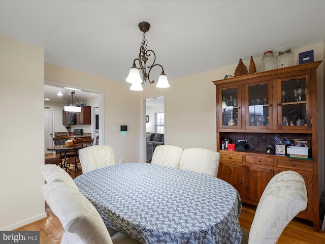 dining area featuring an inviting chandelier and light wood-type flooring