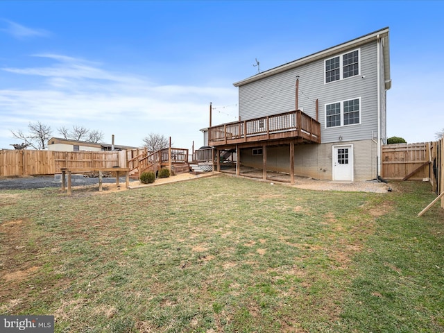 back of property featuring a wooden deck and a lawn