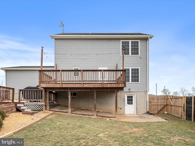 back of property with a deck and a lawn