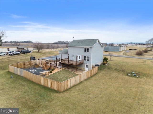 back of house featuring a wooden deck and a yard