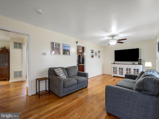 living room with wood-type flooring and ceiling fan