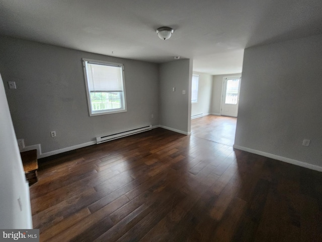 empty room with baseboard heating and dark wood-type flooring