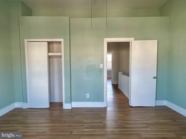 unfurnished bedroom featuring dark wood-type flooring and a closet