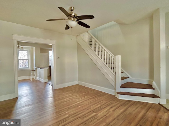 staircase featuring hardwood / wood-style floors and ceiling fan