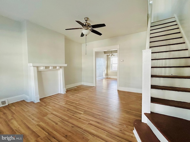 unfurnished living room featuring ceiling fan and light wood-type flooring