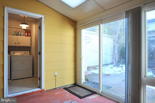 entryway with lofted ceiling, washer / clothes dryer, plenty of natural light, and wooden walls