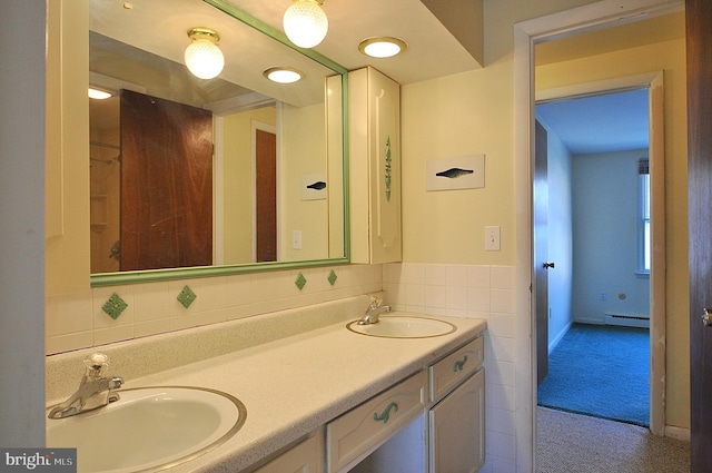 bathroom featuring baseboard heating, vanity, and tile walls