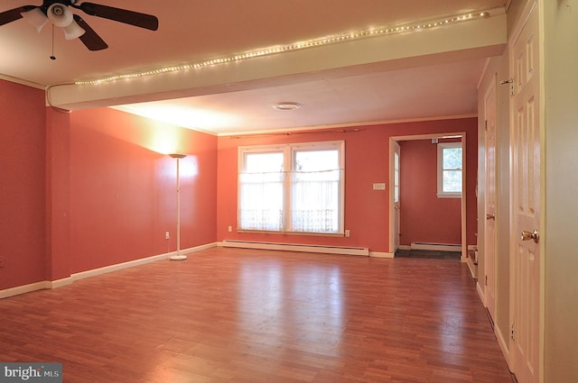 interior space featuring a baseboard heating unit, hardwood / wood-style flooring, ornamental molding, and a healthy amount of sunlight