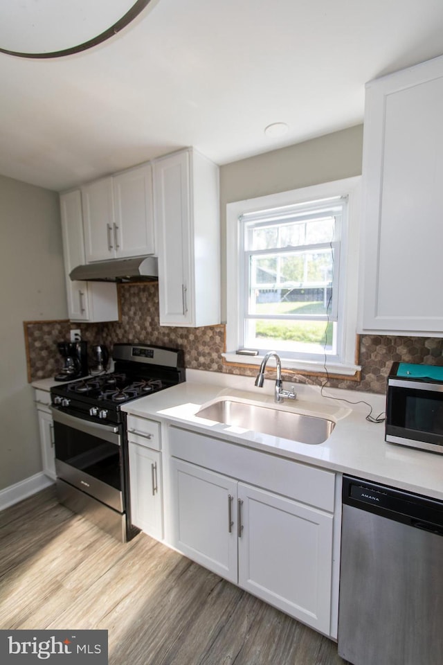 kitchen featuring stainless steel appliances, white cabinetry, and sink