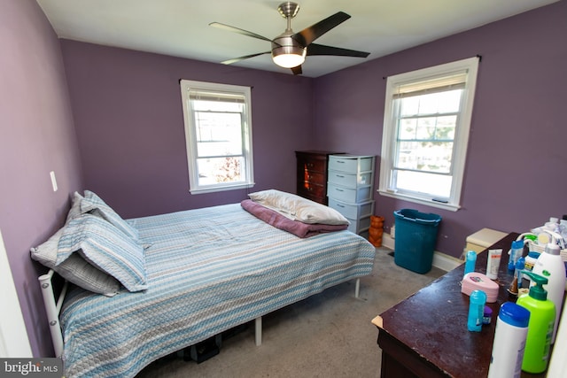 bedroom featuring multiple windows, light carpet, and ceiling fan